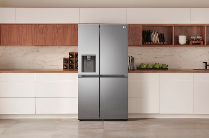 Réfrigérateur Américain LG GSJV51DSXE Argent Foncé avec distributeur d'eau et de glace, intégré élégamment dans une cuisine moderne aux armoires blanches et en bois.