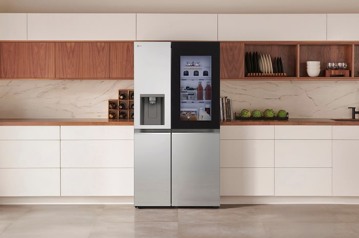 Réfrigérateur Américain InstaView LG GSGV80PYLD Argent Premium avec distributeur d'eau et de glace, intégré élégamment dans une cuisine moderne aux armoires blanches et en bois.