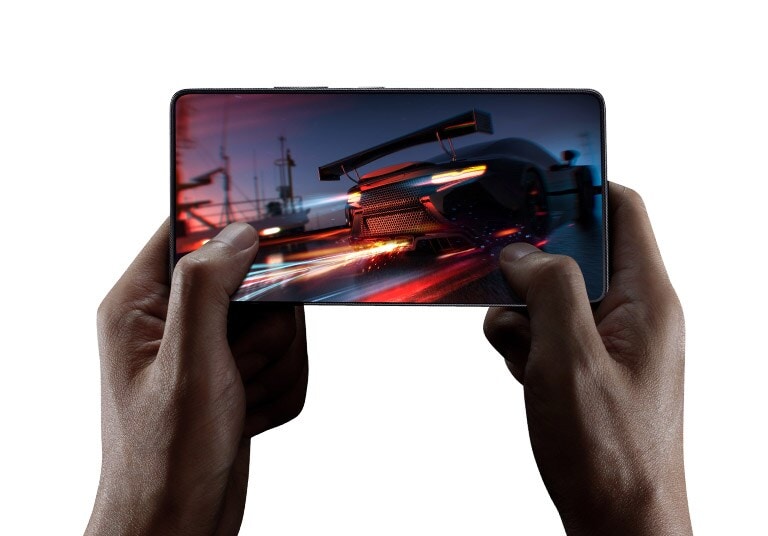 Gros plan d’une main jouant à un jeu de voiture sur un téléphone portable.