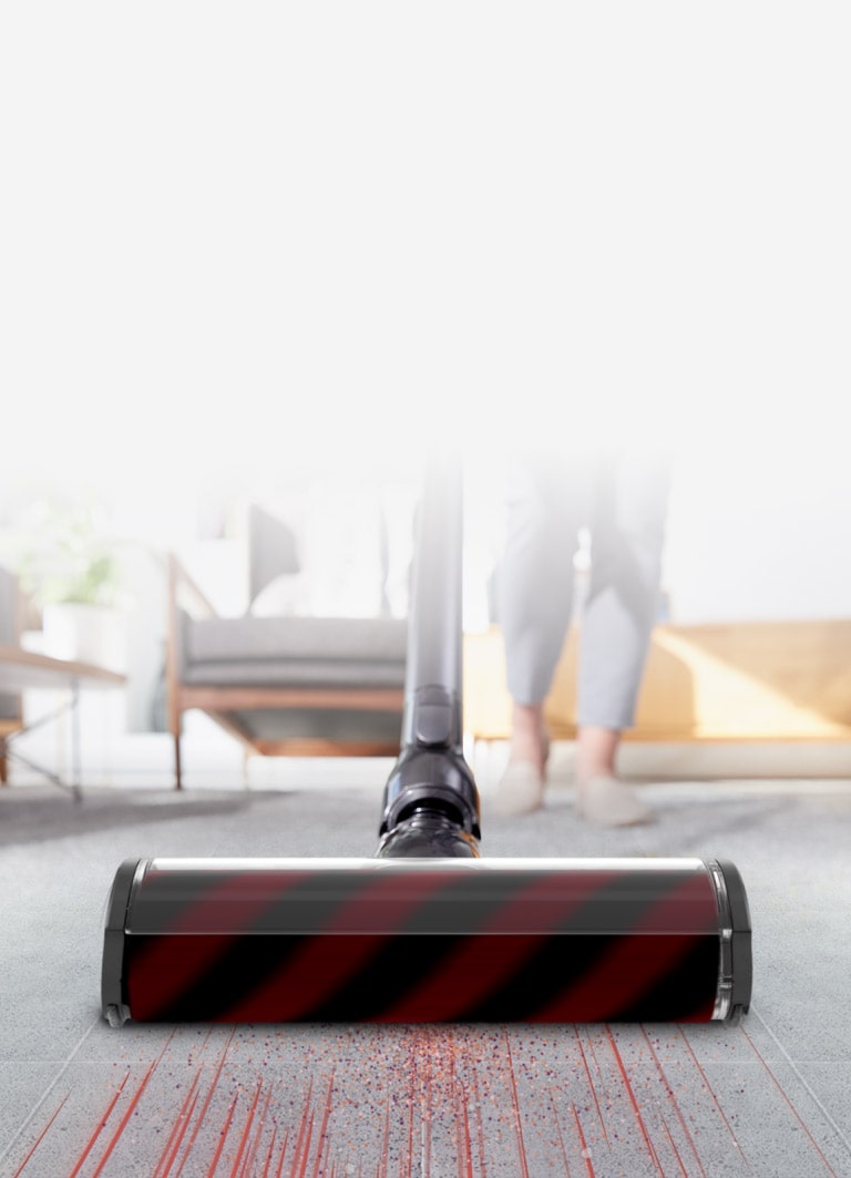 The head of the vacuum cleaner is quickly sucking up dust on the carpet showing strong suction capability.