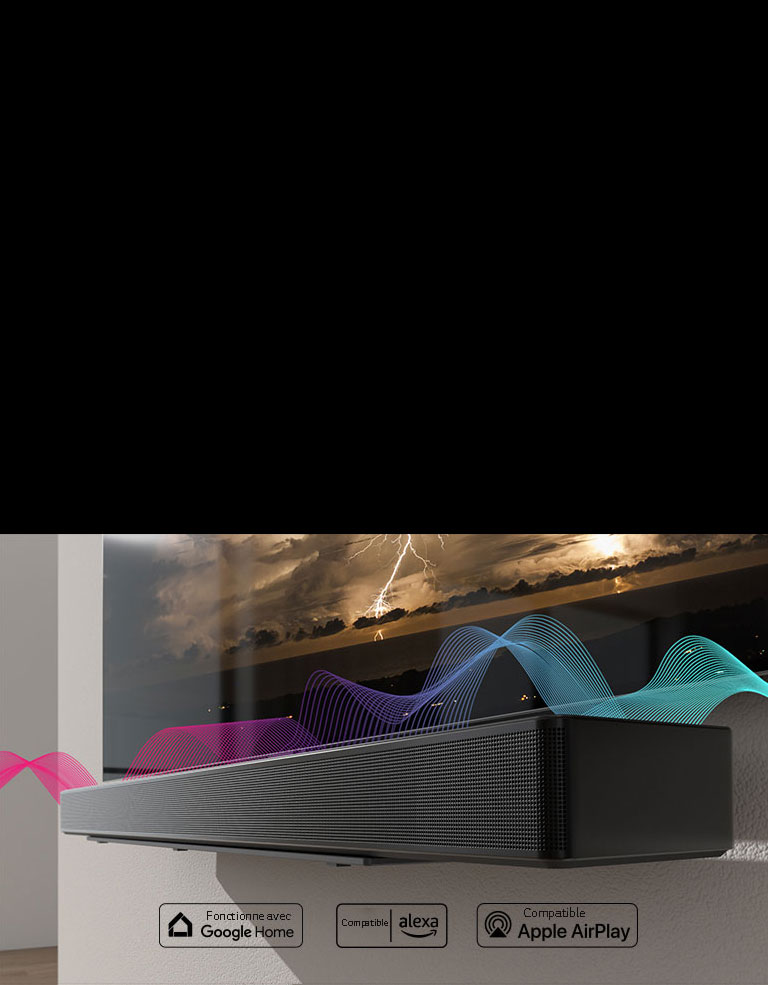 La barre de son est accrochée au mur avec le téléviseur juste au-dessus d’elle. Des ondes sonores passent entre les deux appareils, changeant leurs couleurs du rouge au bleu.