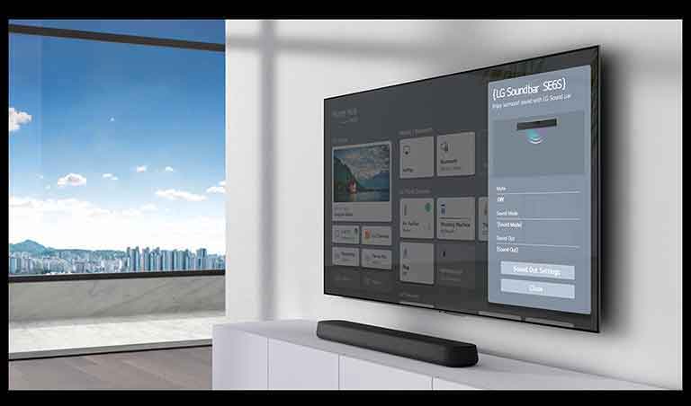 L’écran des réglages de la barre de son LG est affiché sur l’écran du téléviseur monté au mur. La barre de son est également fixée au mur en dessous du téléviseur.