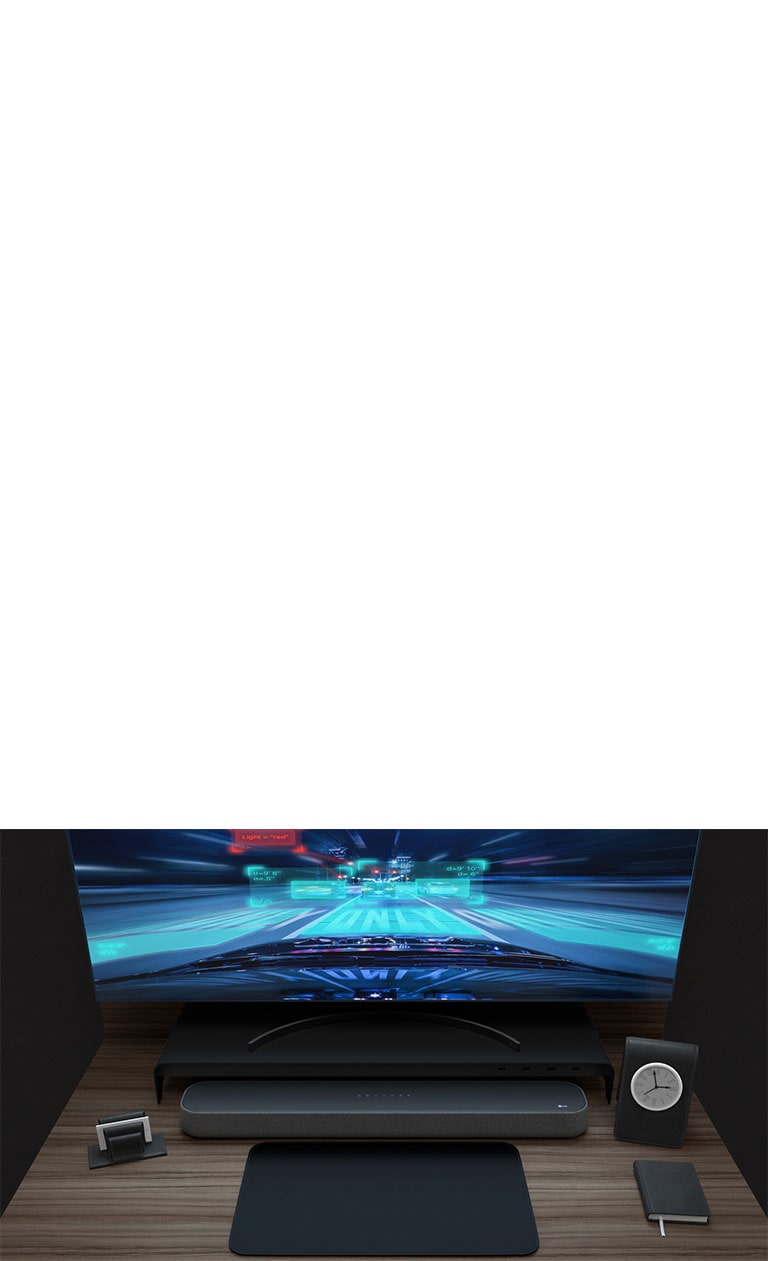 Une barre de son, un moniteur incurvé et une petite horloge sont placés sur un bureau en bois. Un jeu de course est affiché sur le moniteur pour illustrer ses performances en jeu.