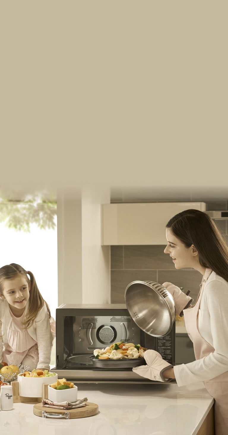 Femme qui cuisine pour sa fille avec un micro-ondes