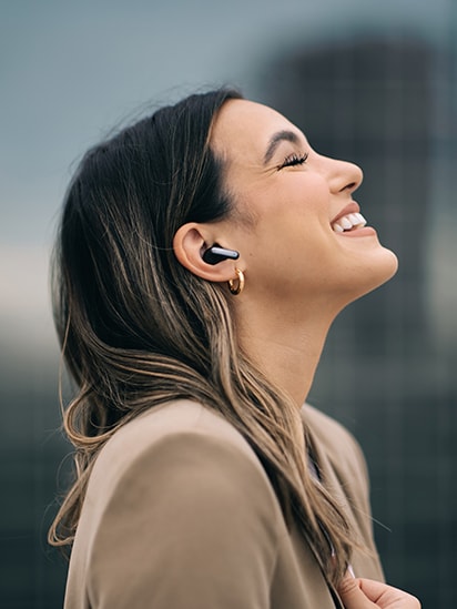 Femme portant des TONE Free Black et profitant de musique avec les yeux fermés