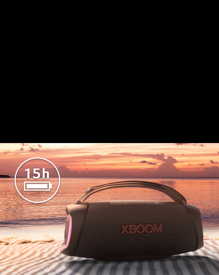 L'enceinte est placée sur une serviette de plage. Devant le haut-parleur, on voit un coucher de soleil sur la plage pour illustrer le fait que ce haut-parleur peut être utilisé plus longtemps.