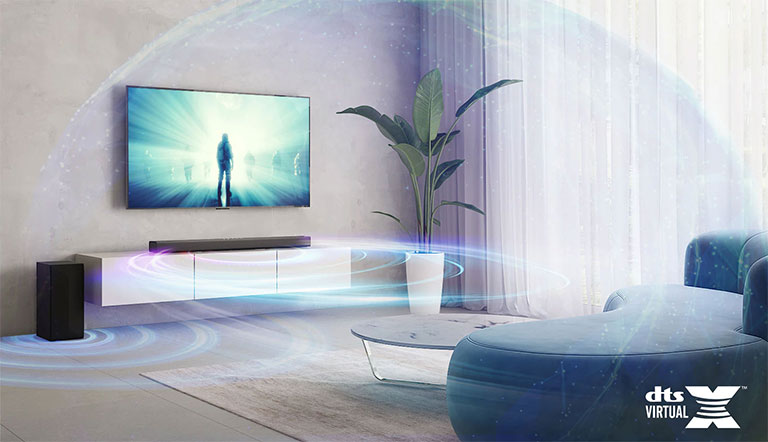 V obývacím pokoji visí na zdi televizor LG. Na televizní obrazovce se přehraje film. Soundbar LG je umístěn těsně pod televizorem na béžové polici se zadním reproduktorem umístěným vlevo. Logo DTS Virtual:X se zobrazí v pravém dolním rohu obrázku.