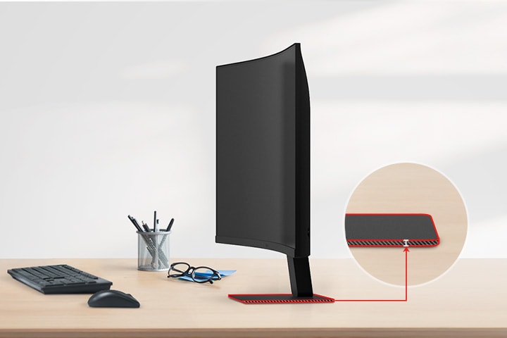 Un moniteur QHD avec un support ultra-fin est posé sur le bureau, avec un porte-crayon, des lunettes, un clavier et une souris à côté.
