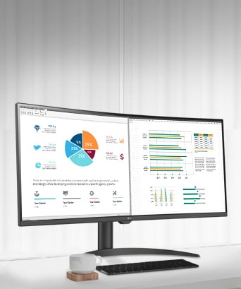 Auf dem Tisch steht ein intelligenter Monitor. Auf diesem ist ein Dokument aus dem Home Office zu sehen, an dem gerade gearbeitet wird. Links vom Monitor befindet sich eine Tasse mit Henkel, rechts ein Mobiltelefon, ein Stifthalter und ein Standfuß.