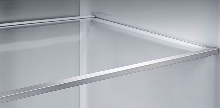 Vue en diagonale de l’étagère avec des panneaux métalliques à l’intérieur du réfrigérateur.