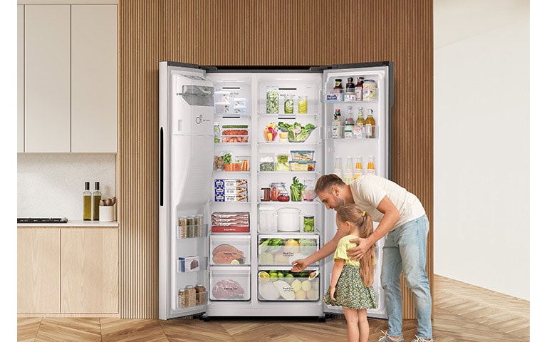 L'homme et l'enfant retirent des produits du réfrigérateur, en laissant la porte ouverte