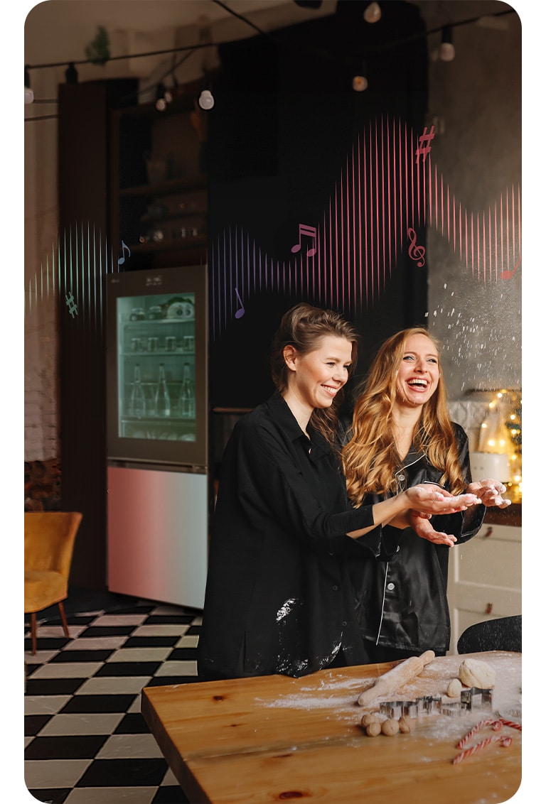 Les images de deux femmes faisant la fête dans une cuisine, et l’image d’un réfrigérateur étincelant.
