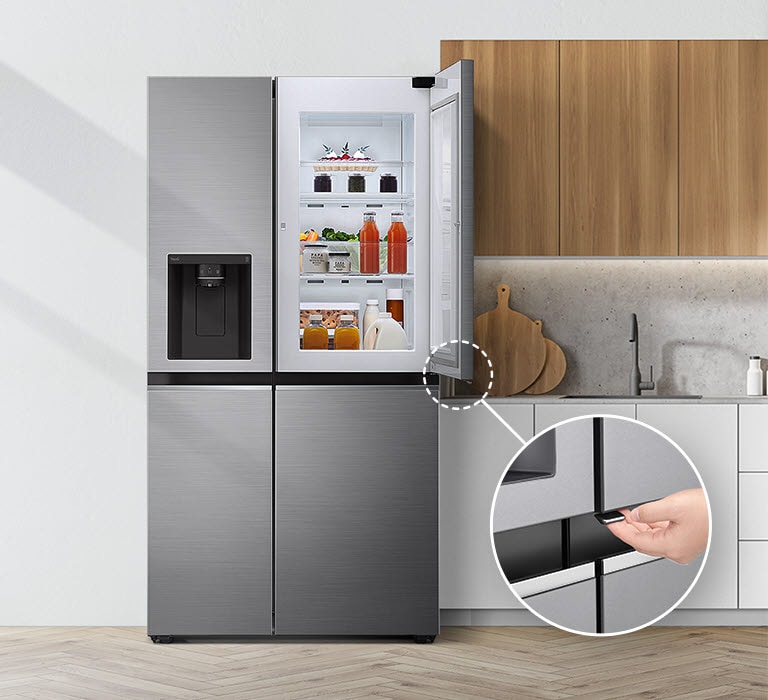 Réfrigérateur LG en acier inoxydable dans une cuisine moderne, porte ouverte montrant boissons et aliments rangés.