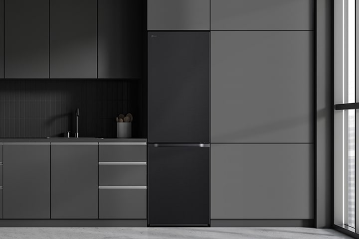 Cuisine moderne avec un réfrigérateur qui s'intègre parfaitement dans les armoires environnantes, ressemblant à un modèle encastré.
