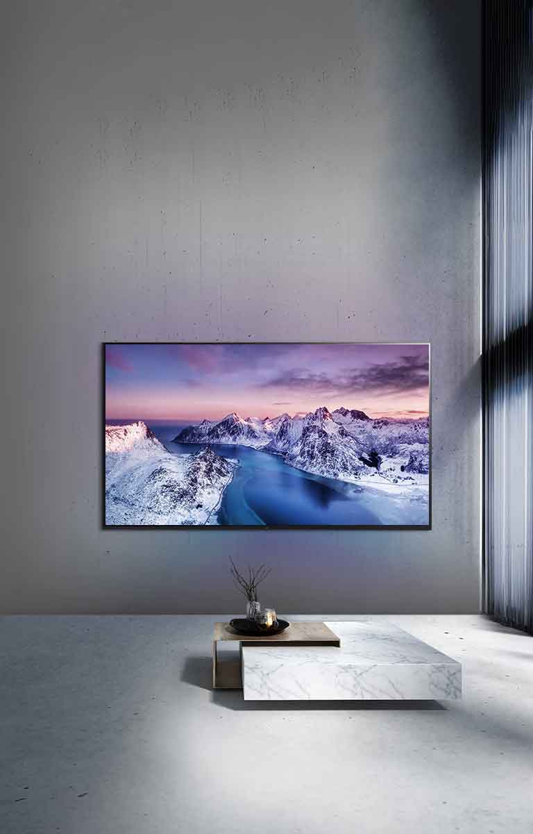 Un téléviseur UHD fixé au mur derrière une table décorée dans un style zen.