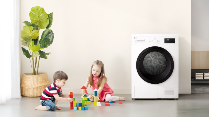 Deux enfants jouant avec des blocs de couleur près d’un sèche-linge