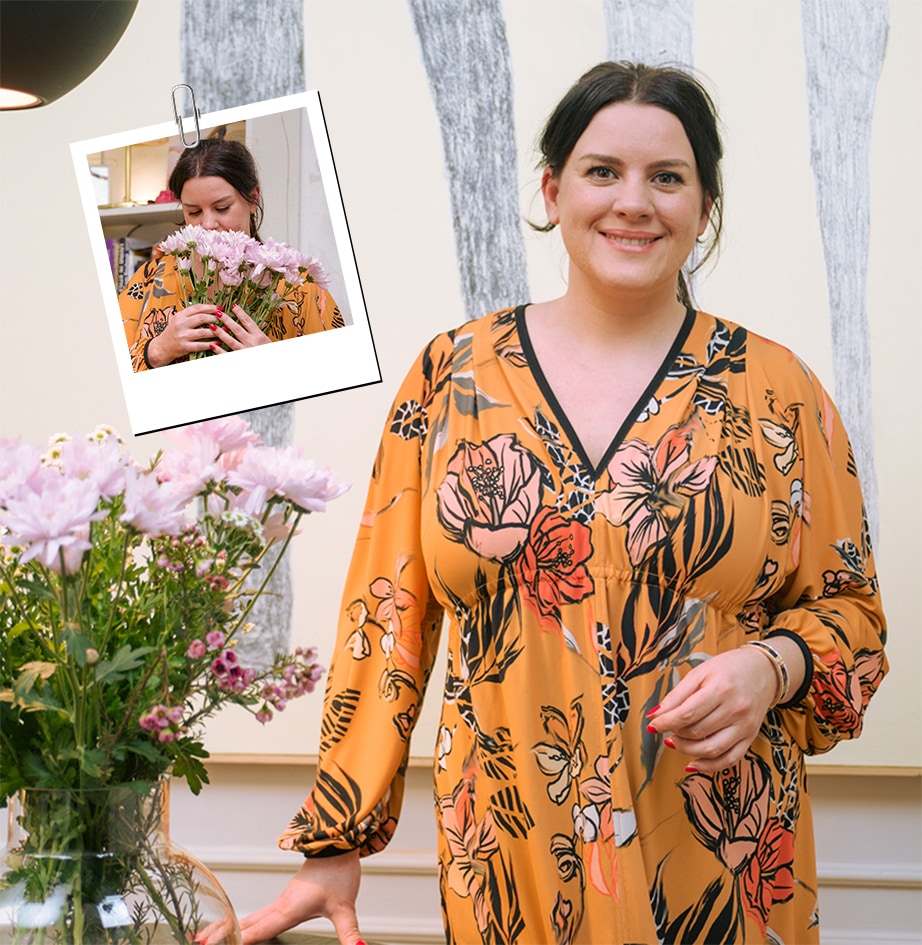C'est une image d'une femme regardant droit devant elle à côté d'une fleur rose.
