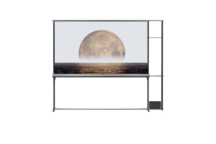 Front view of the LG OLED T with a screen depicting a moon above the sea, showing the ZeroConnect box on the shelf to the right.