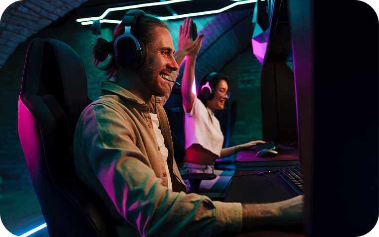 Twee gamers concentreerden zich intens op een 4K-monitor in een slecht verlichte kamer en genoten van een meeslepende videogame-ervaring.