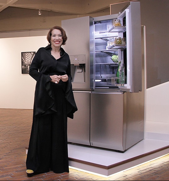 a woman is standing in front of lg signature refrigerator at launching event in colombia