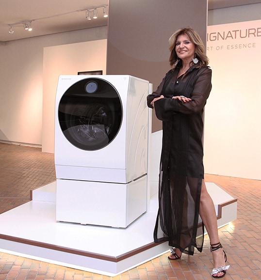a woman is standing in front of lg signature washing machine at launching event in colombia