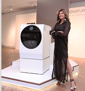 a woman is standing in front of lg signature washing machine at launching event in colombia