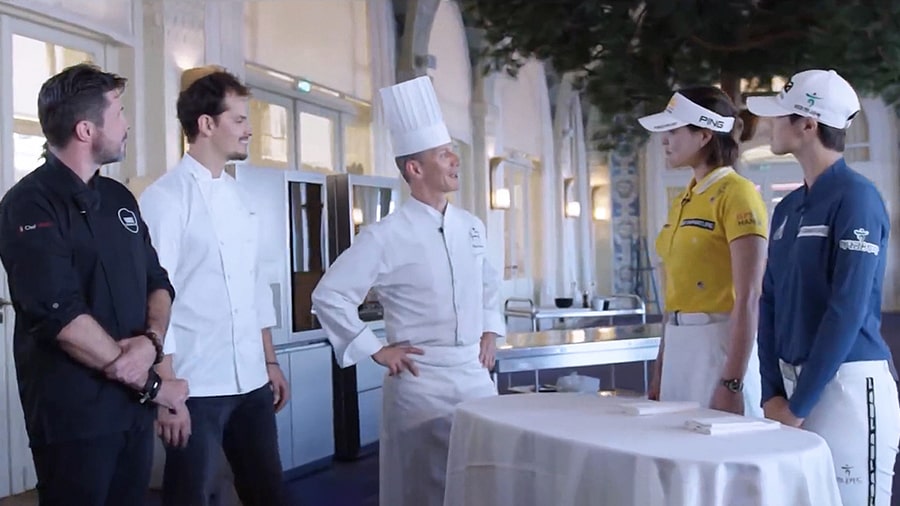 chefs and two golfers are standing and talking together in the kitchen at the lg signature and evian championship event