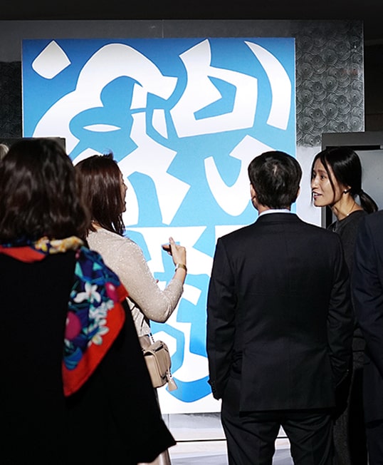 several people are standing in front of artistic picture of lg signature wine cellar at the lg signature artweek in germany