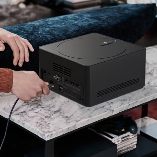 The man is plugging an HDMI cable into the back of the zero connect box.