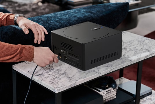 The man is plugging an HDMI cable into the back of the zero connect box.