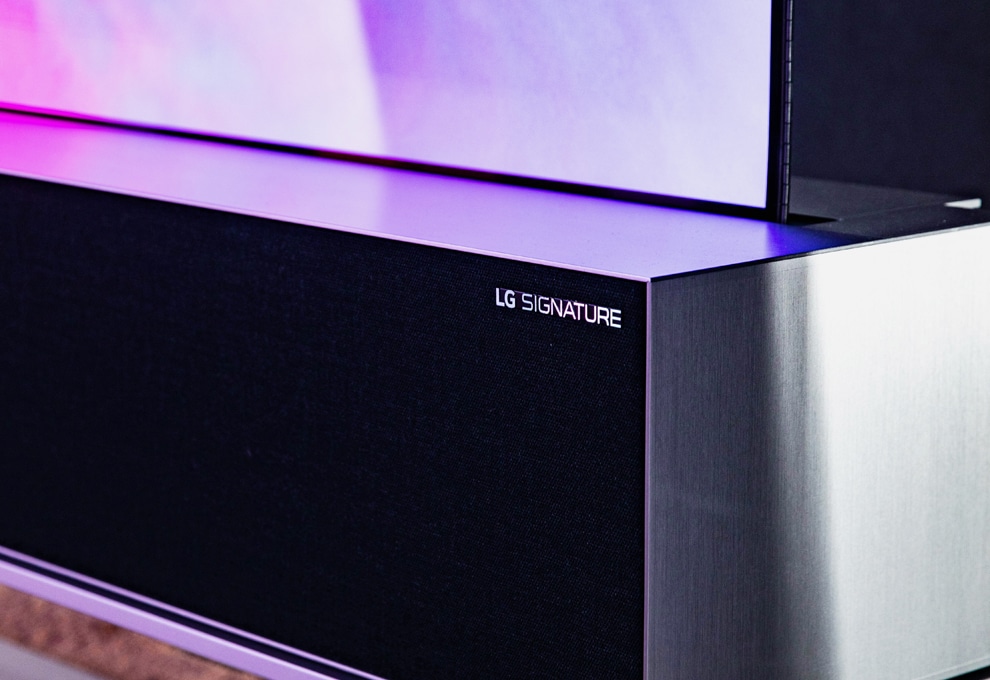 Un'immagine dell'altoparlante TV OLED arrotolabile LG SIGNATURE situato in uno spazio di colore grigio.