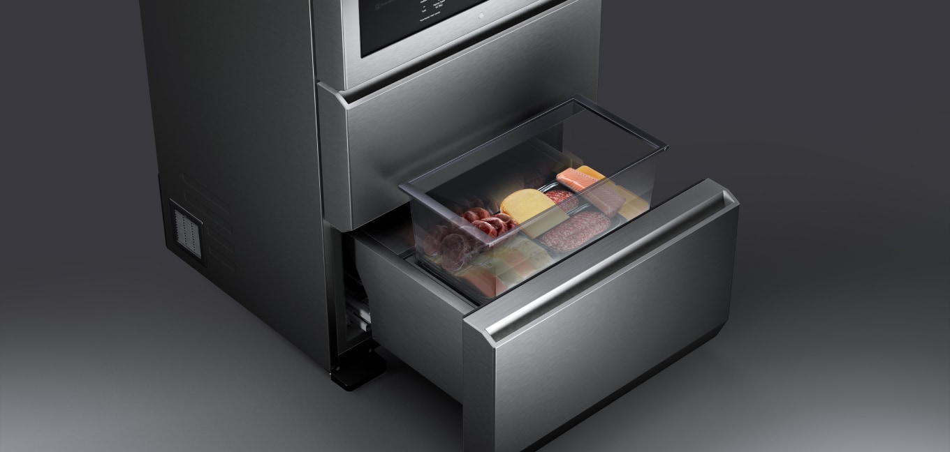 Top-down image of the convertible drawer. A portion of the drawer has been lifted to reveal various cold meats and cheeses stored inside and to allow easy access to the drawer's contents.
