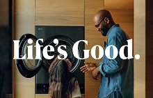 A father and daughter sharing a happy moment next to an open LG WashTower AI, with "Life's Good." text overlay.