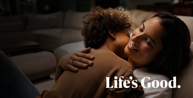 A woman smiling while embracing a young child, with the small text "Life's Good" below.