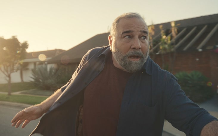 The face of a middle-aged man enjoying a longboard.
