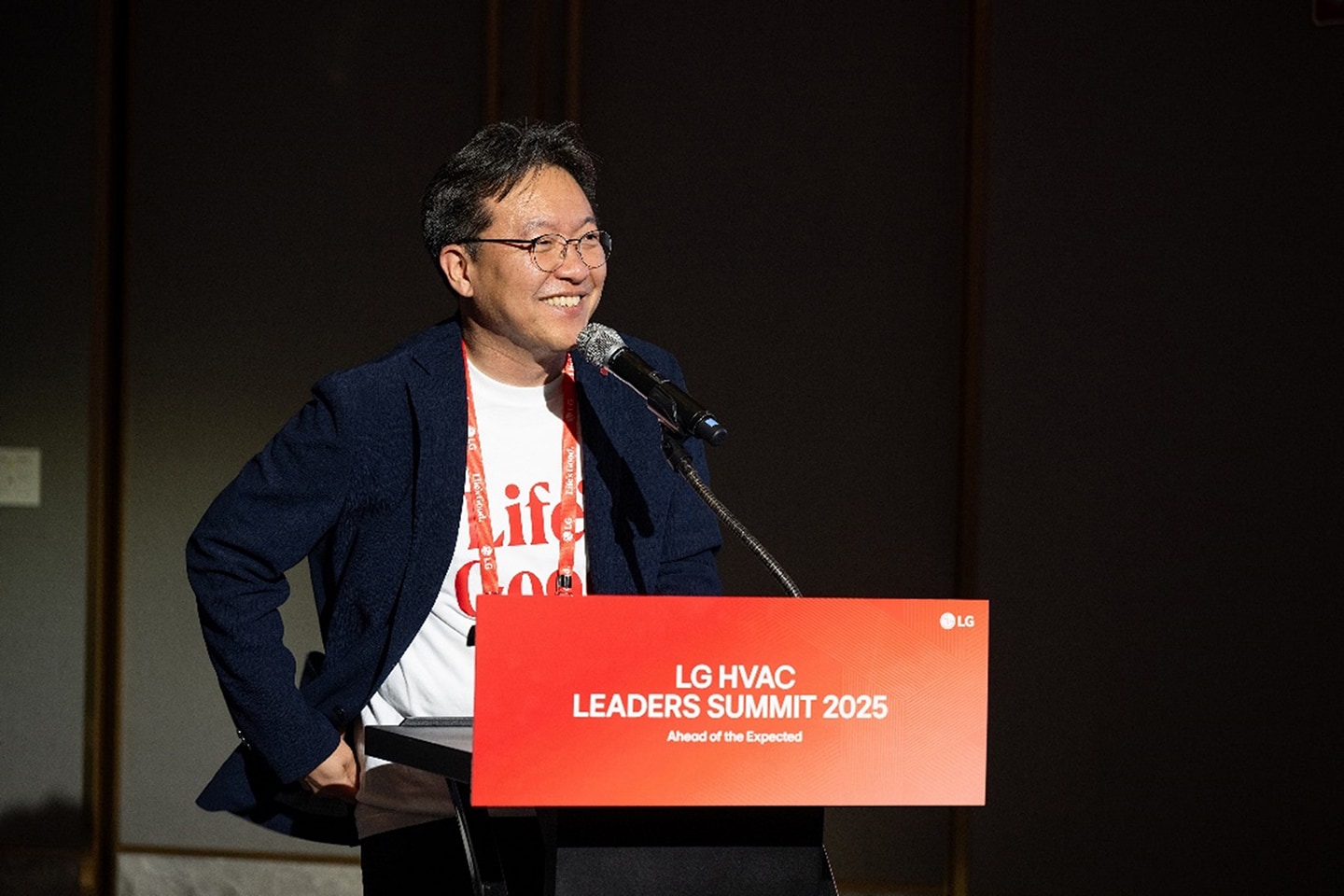 A photo of a man standing on a conference podium