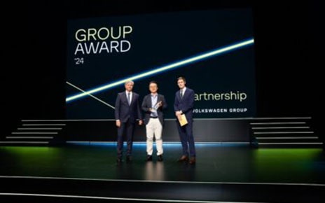 A picture of three men smiling on stage at Volkswagen Group Award 2024