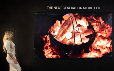 A photo of a woman looking at the woodfire image displayed on the LG Micro LED display