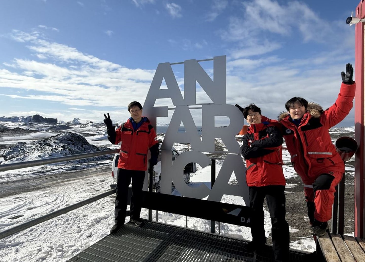 A photo of a group in front of the sign 'Antarctica'