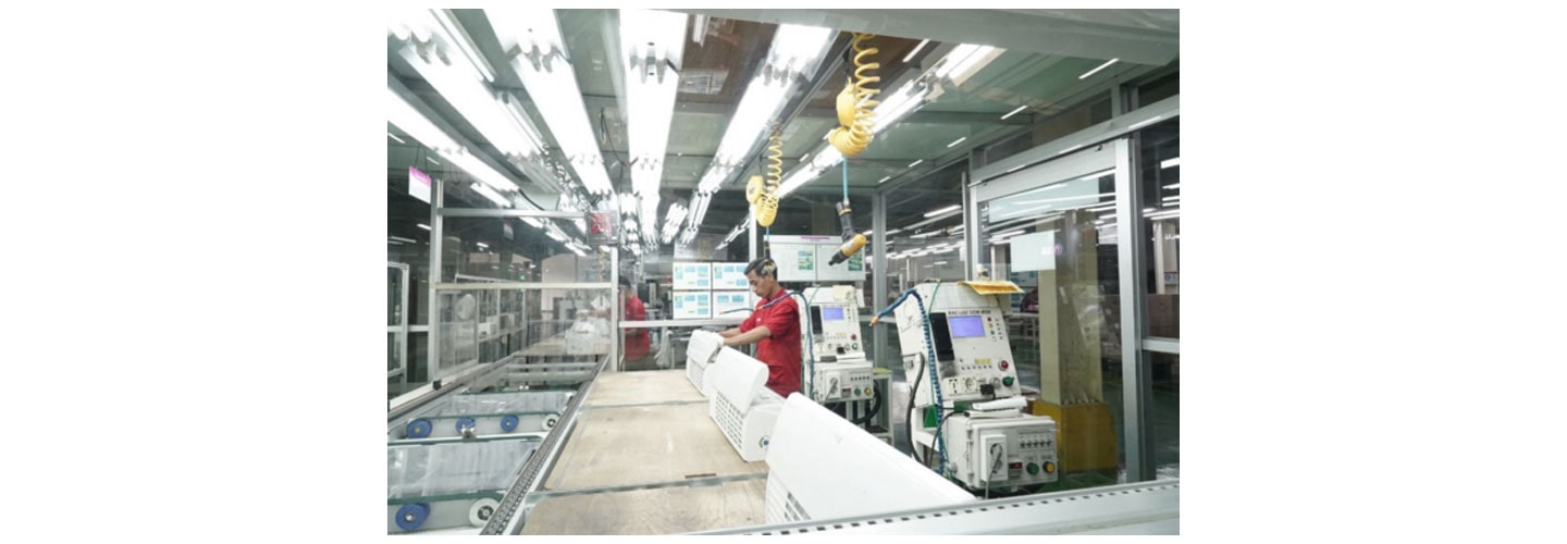 A photo of two workers at the newly expanded factory to produce LG appliances