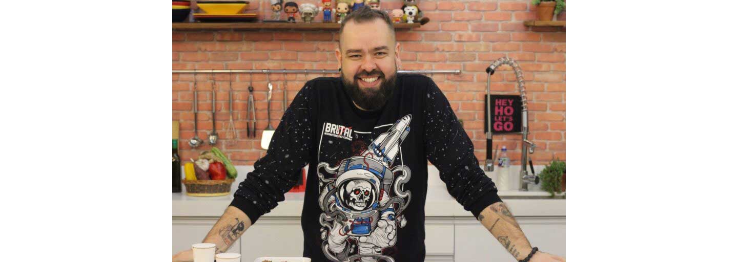 Filipe Nascimento, the star and founder of Micro Sobrevivência, smiles for the camera in his kitchen