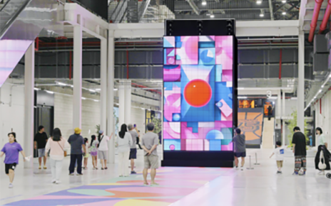 A picture of the kinetic LED signage displaying artwork with people walking by