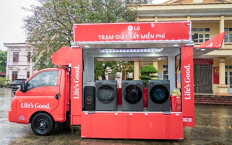 A photo of a red truck with the LG logo fully equipped with washers and dryers 