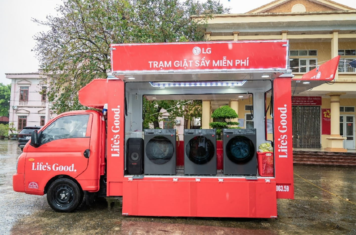 A photo of a red truck with the LG logo fully equipped with washers and dryers 