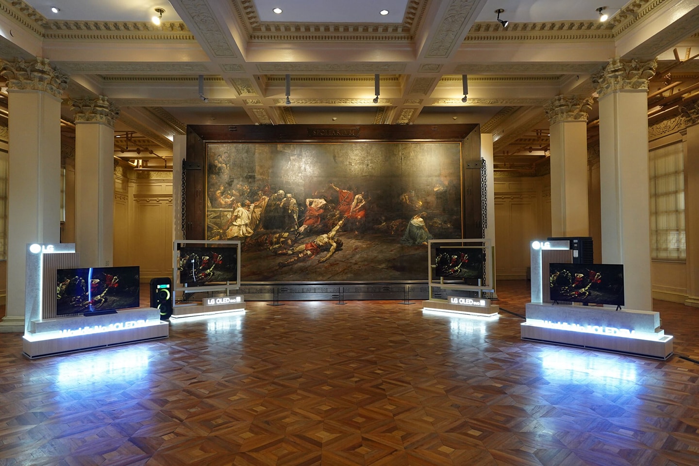 A photo of LG OLED TVs on display with lights in the gallery