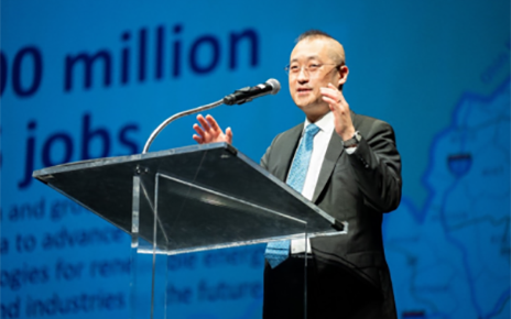 A photo of Sokwoo Rhee on stage speaking