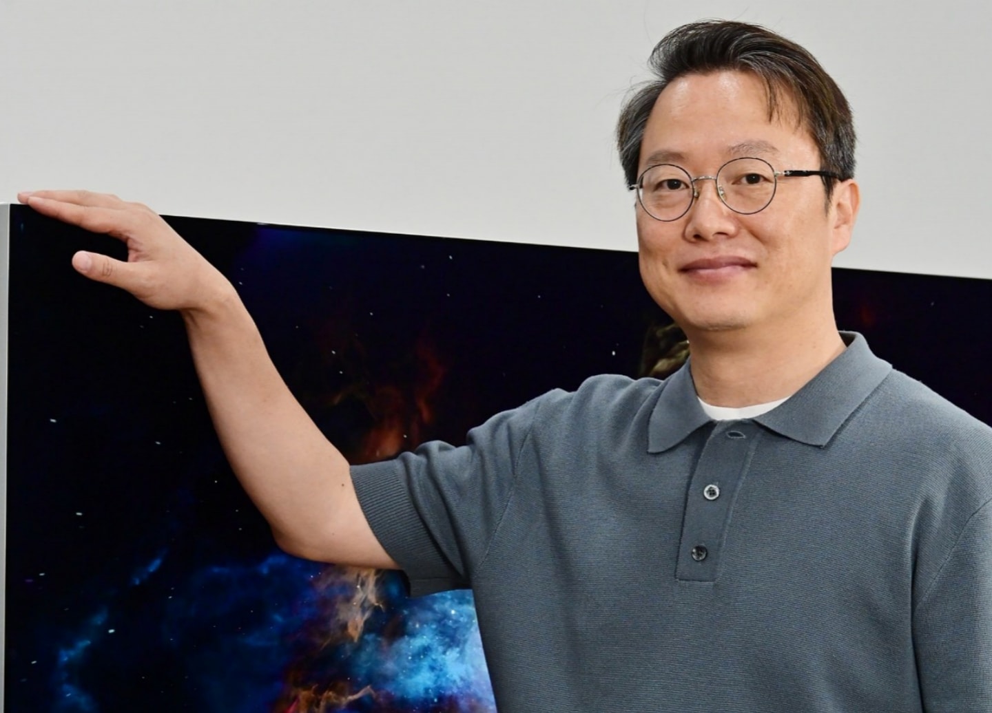 LG expert standing beside an LG OLED evo TV featuring Reflection Free Premium for bright-room viewing.