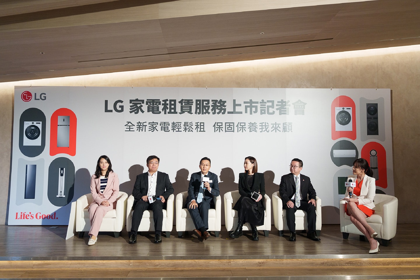 A photo of industry experts and retail leaders sitting down, holding a microphone and answering questions