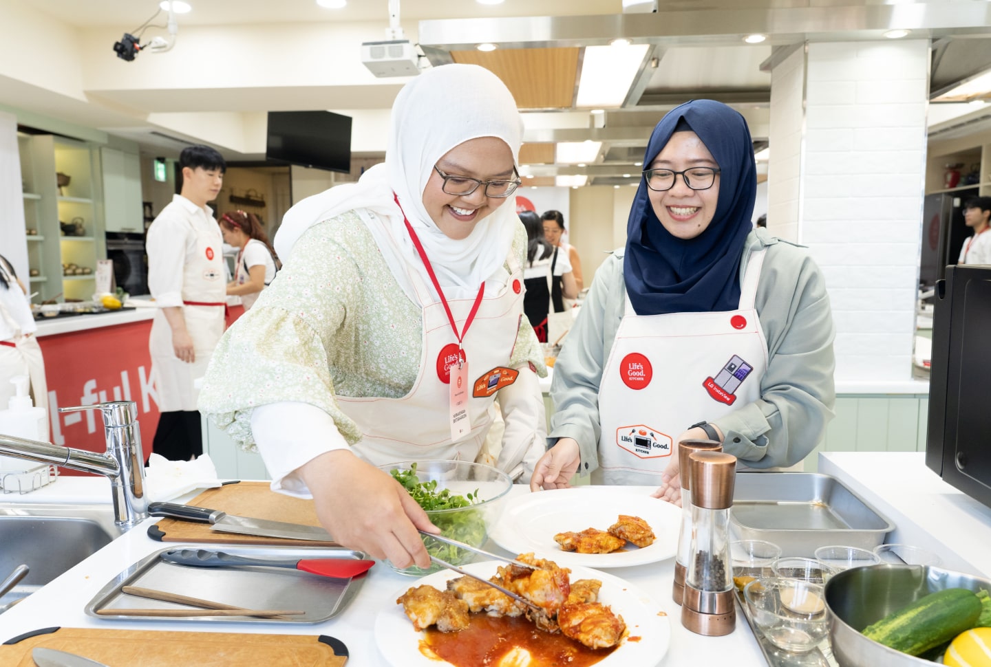 Two women prepare and plate food during the Seoul-ful Kitchen Challenge.