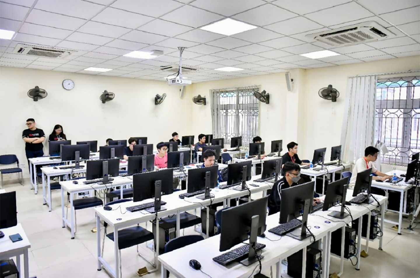 A photo of Vietnamese students sit in a computer lab as they complete the LG Dream Code 2024 program